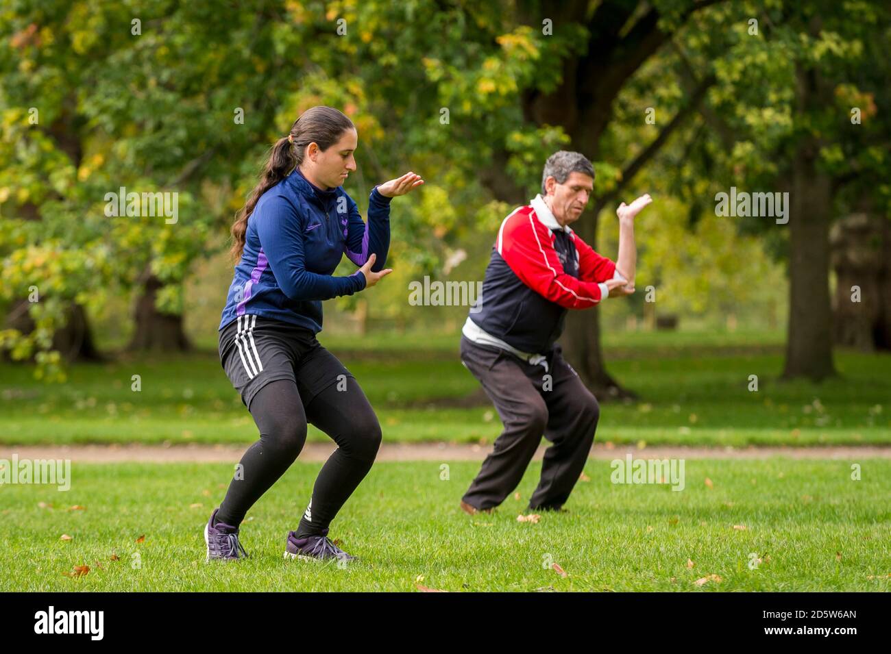 London, Großbritannien. 14. Oktober 2020. UK Wetter: Ein Paar übt Tai Chi, auch Tai Chi chuan genannt, als die Blätter auf Bäumen im Green Park beginnen, ihre Herbstfarbe zu nehmen. Ursprünglich als Kampfkunst im China des 13. Jahrhunderts entwickelt, wird Tai Chi heute weltweit als gesundheitsfördernde Übung praktiziert und verbindet tiefes Atmen und Entspannung mit fließenden Bewegungen. Gute Sonneneinbrüche im Frühjahr und Sommer, gefolgt von Regenfällen im September, lassen den diesjährigen Herbstlaub in diesem Jahr besonders eindrucksvoll erscheinen. Kredit: Stephen Chung / Alamy Live Nachrichten Stockfoto