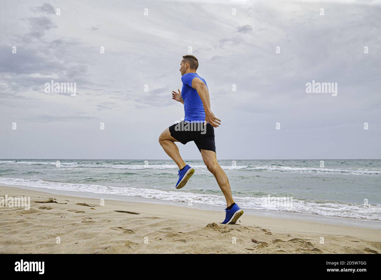 Back man Athlet Läufer laufen auf Meer Sandstrand Stockfoto