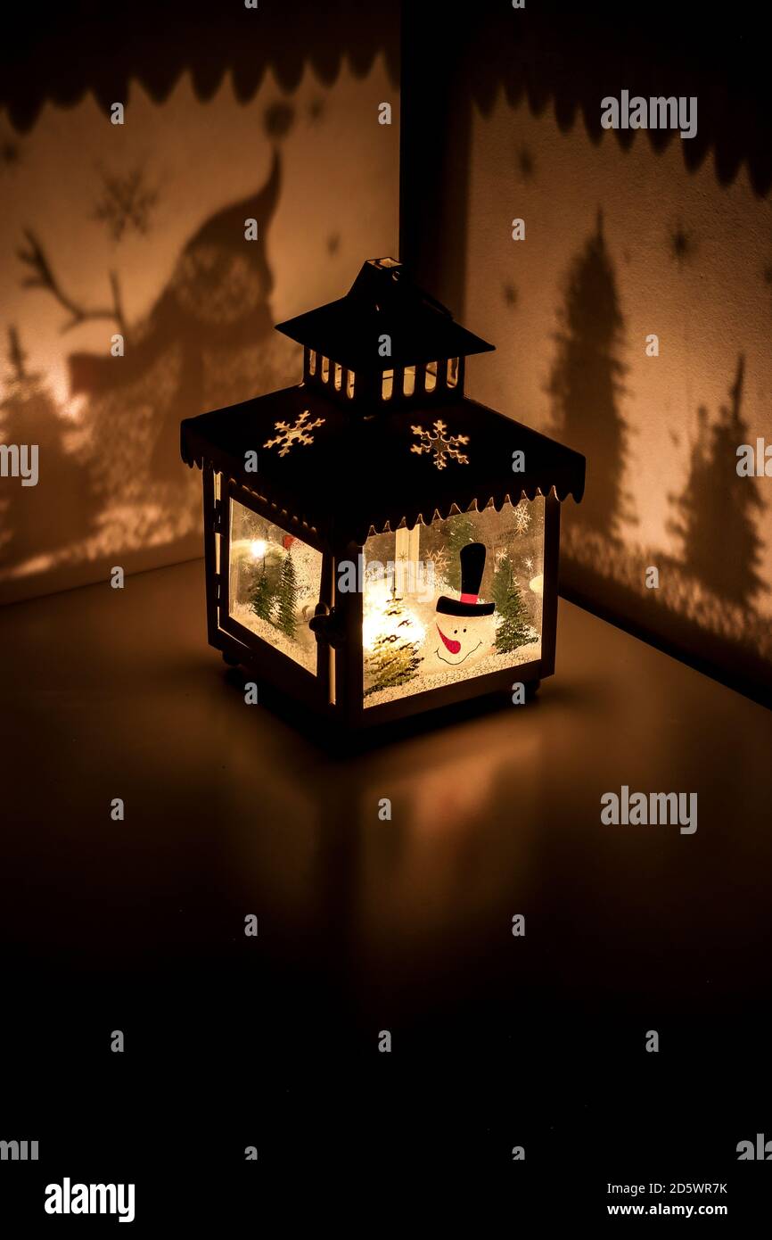 Weihnachten Teelicht Kerze Laterne mit Schneemann werfen Schatten weihnachtsbäume und Schneeflocken Stockfoto