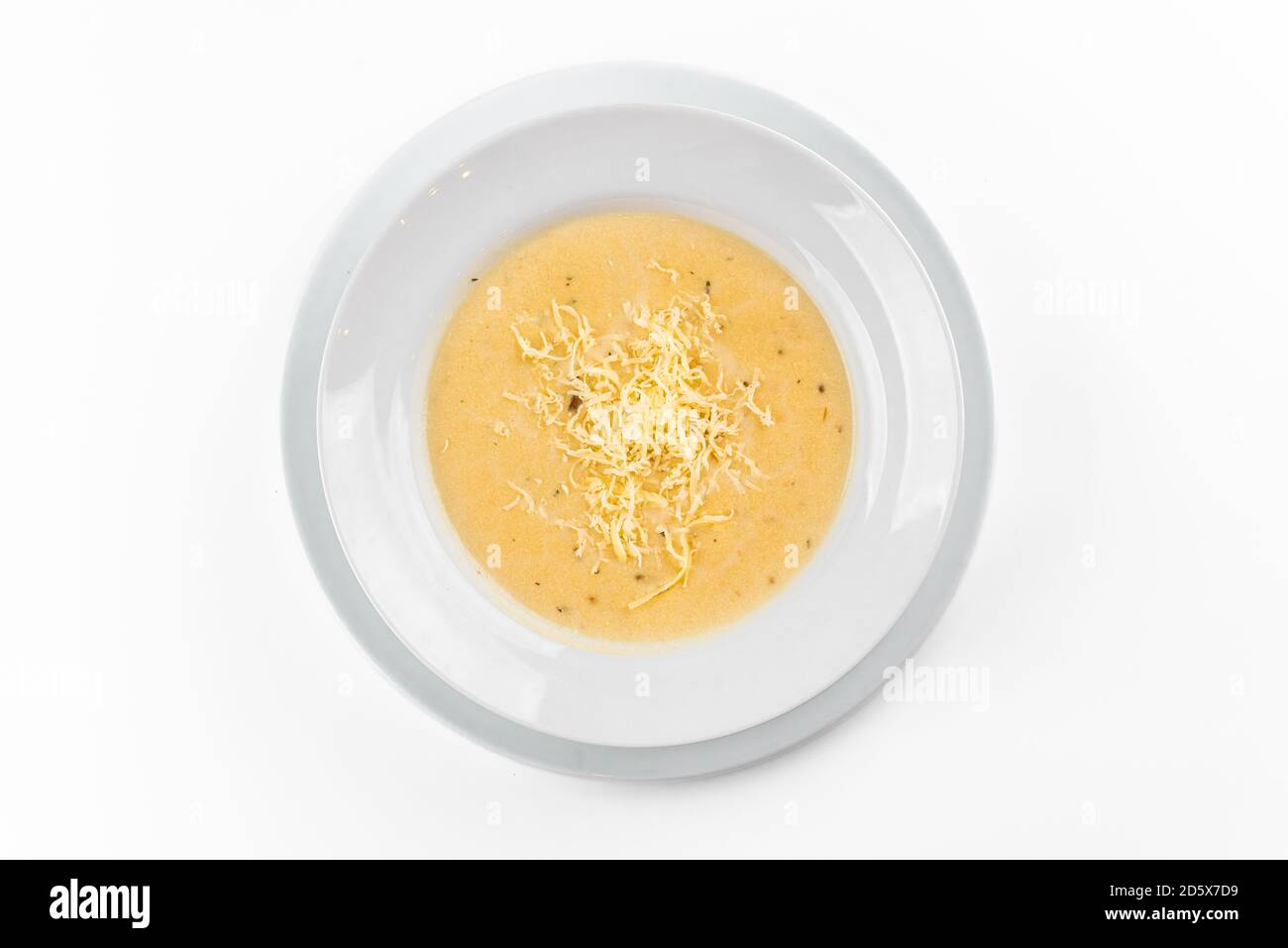 Käsesuppe auf weißem Teller auf weißem Hintergrund Stockfoto