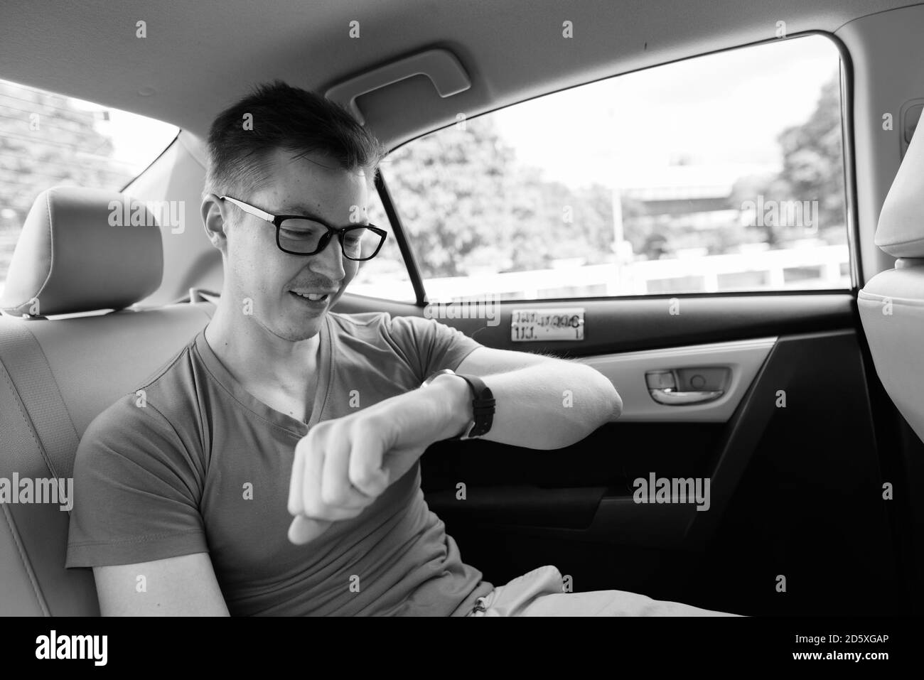 Junger, gutaussehender Tourist im Auto um die Stadt herum Stockfoto