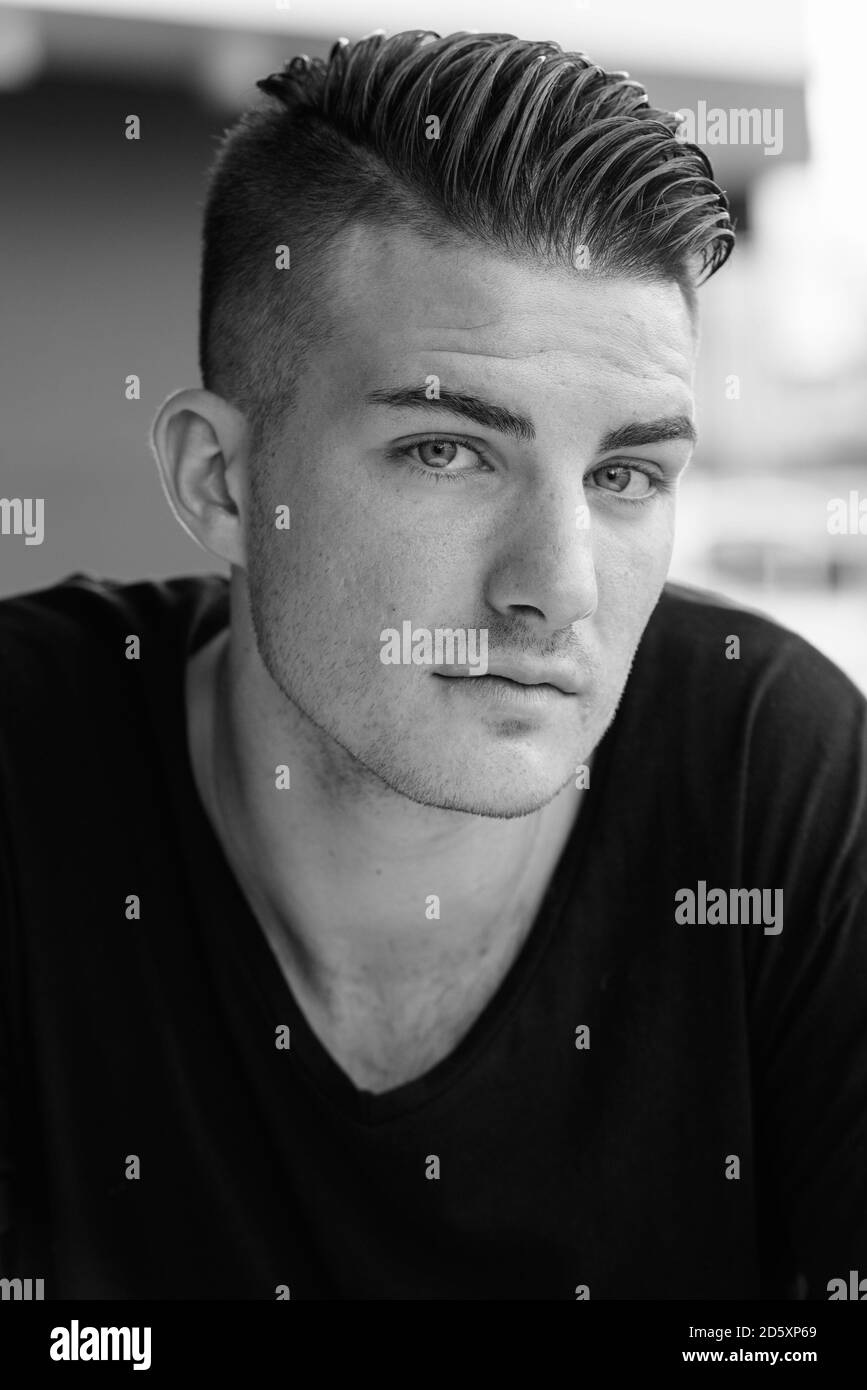 Gesicht der jungen gutaussehenden Mann außerhalb des Café sitzen Stockfoto