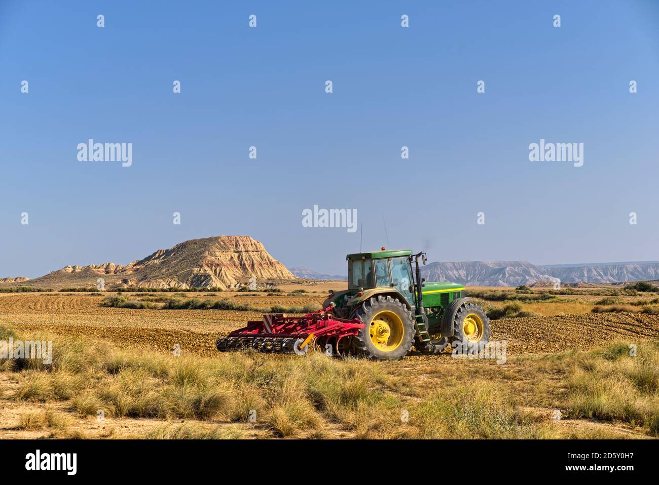 Spanien, Navarra, Bardenas Reales, halbwüstenartige Naturraum Traktor auf Feld Stockfoto