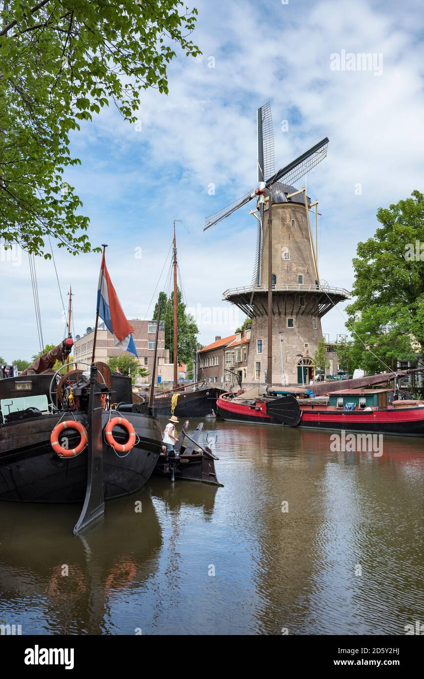 Niederlande, Gouda, Hafen mit traditionellen Segelschiffen und Windmühle Stockfoto