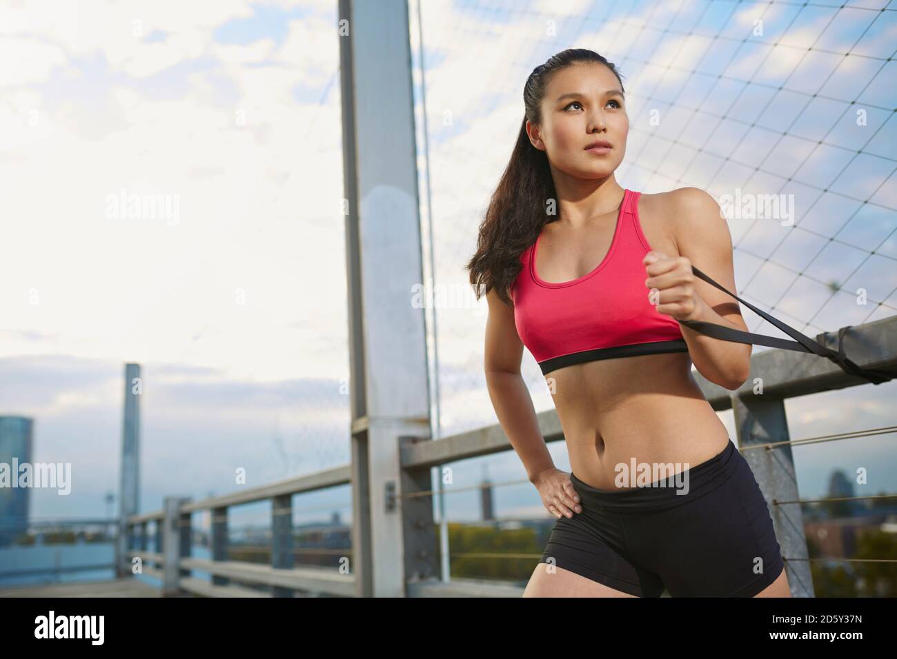 Junge weibliche asiatische Sportlerin tun stretching Übungen mit Fitness band Stockfoto