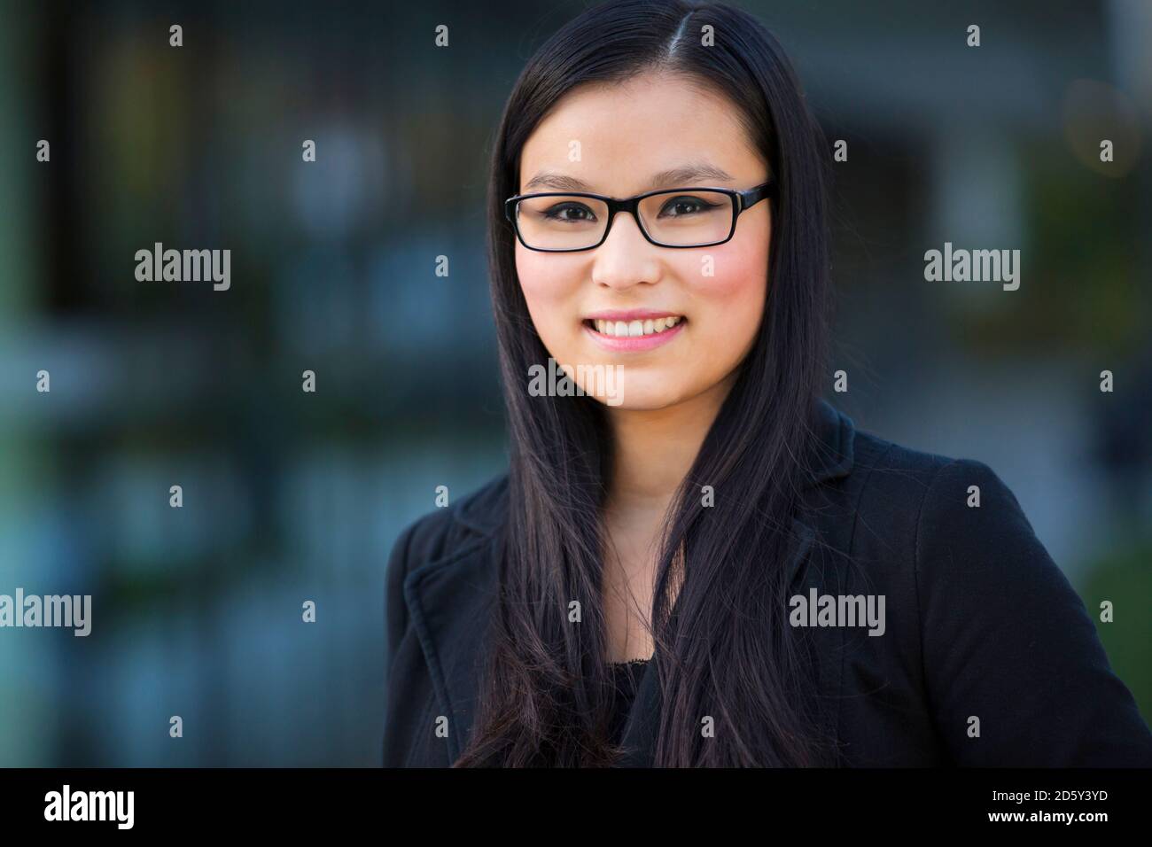 Porträt der lächelnde junge Geschäftsfrau mit Brille Stockfoto