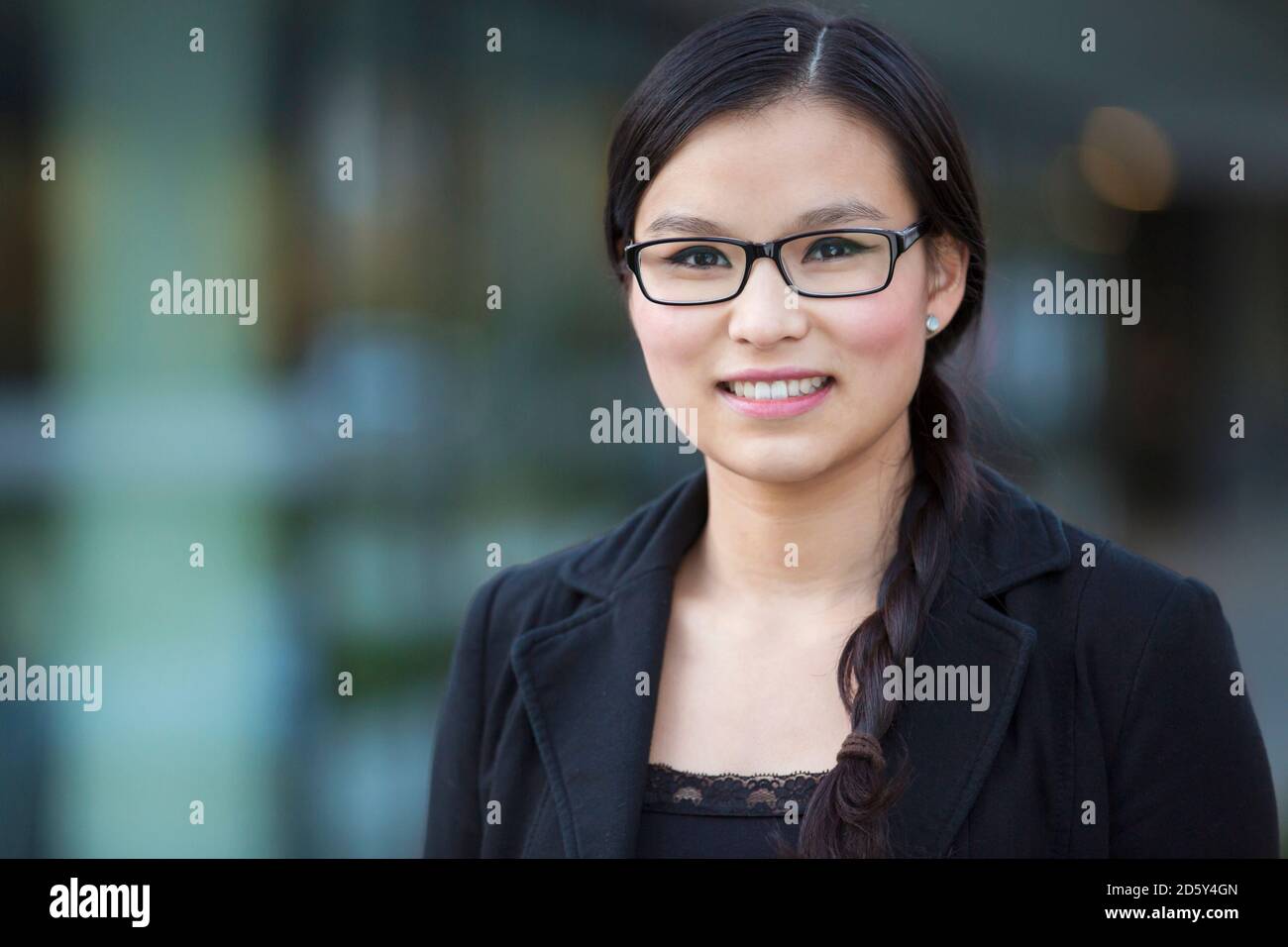 Porträt der lächelnde junge Geschäftsfrau mit Brille Stockfoto