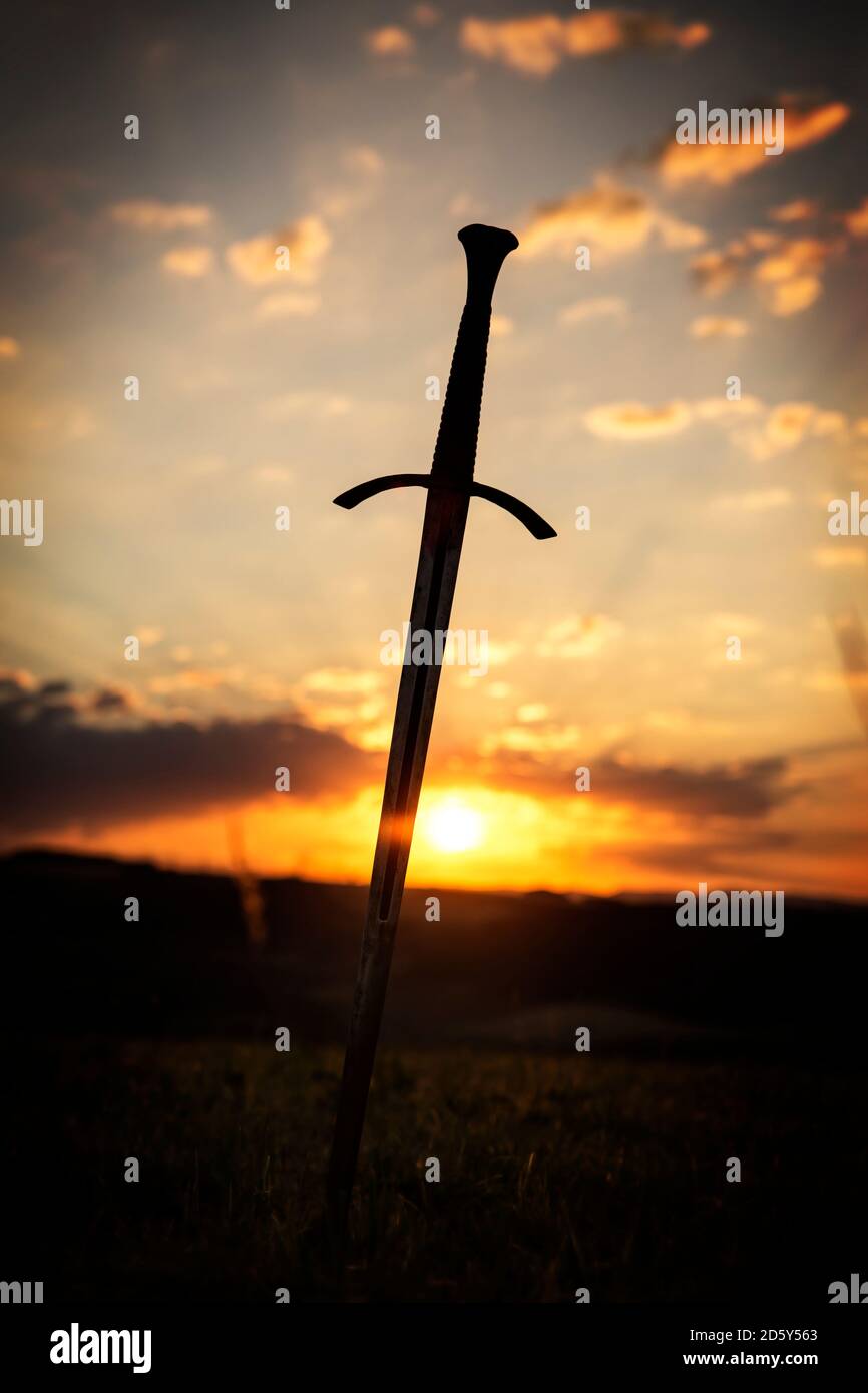 Schwert in ländlicher Landschaft bei Sonnenaufgang Stockfoto