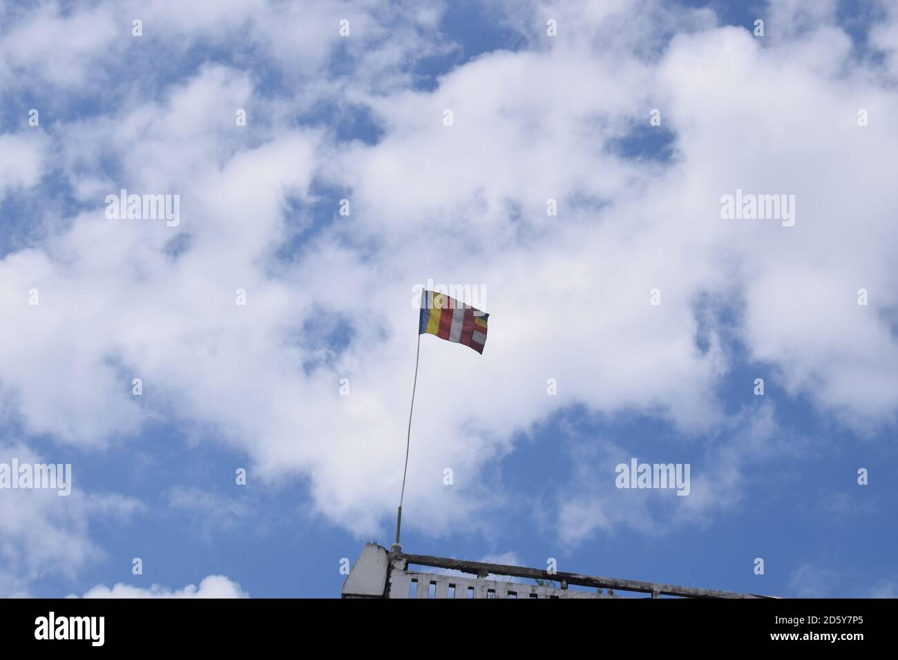 Buddhistische Flagge unter dem blau bewölkten Himmel. Stockfoto