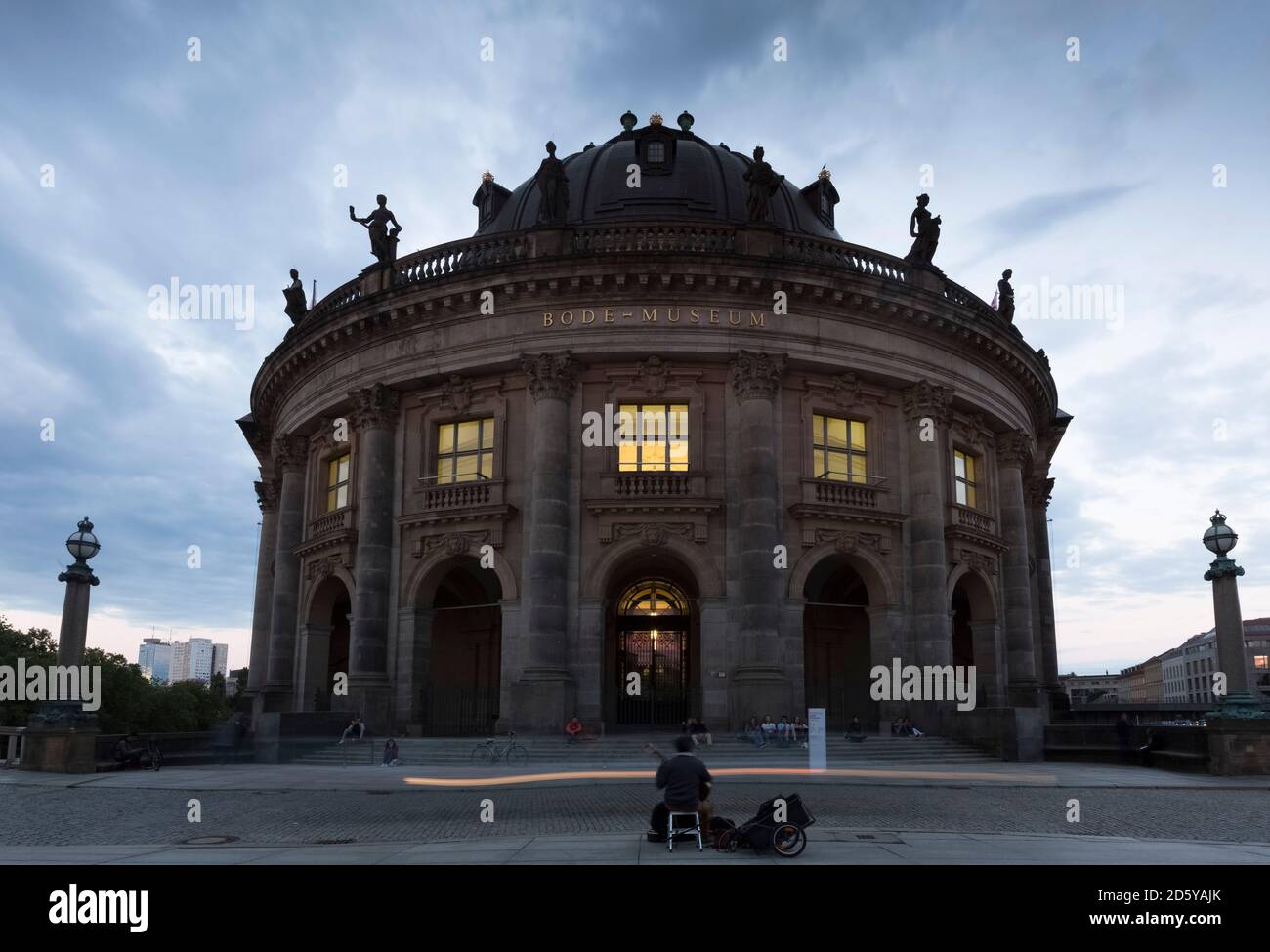 Deutschland, Berlin, Blick auf beleuchtetes Bode Museum auf der Museumsinsel mit Straßenmusiker im Vordergrund Stockfoto