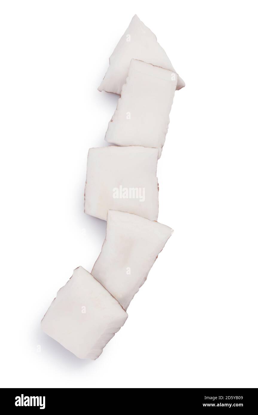 Studioaufnahme von kleinen Kokosnussstücken, gegen die es geschnitten wurde Ein weißer Hintergrund - John Gollop Stockfoto