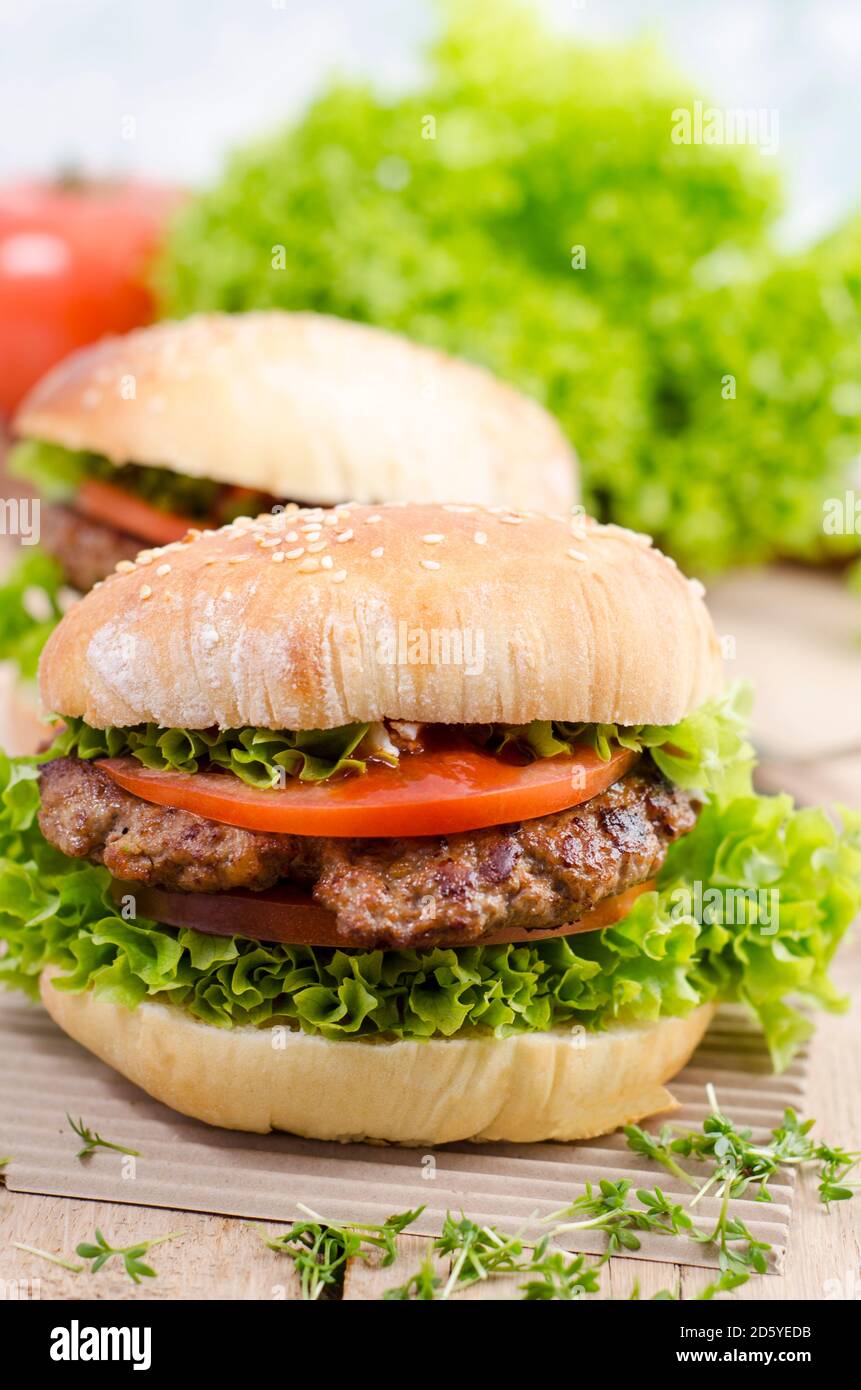 Hausgemachte Hamburger mit Hackfleisch und Salat auf Sesam-roll Stockfoto