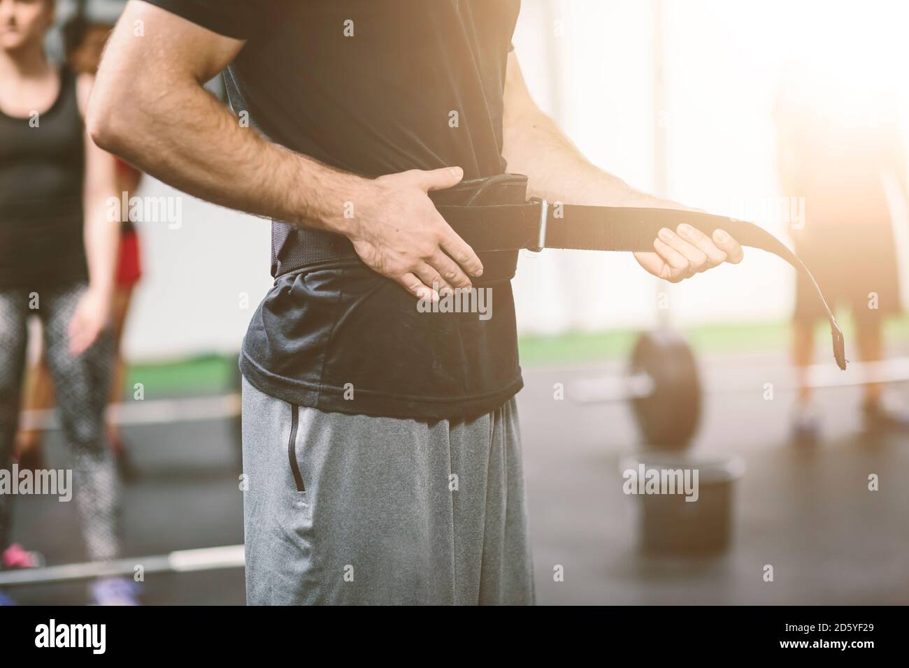 Athlet im Fitnessstudio, der Gewichtheben-Gürtel anlegt Stockfoto