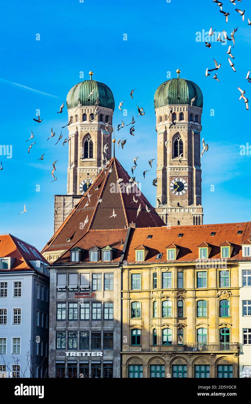 Deutschland, München, Blick auf die Turmspitzen der Liebfrauenkathedrale mit Häusern und Vogelflug im Vordergrund Stockfoto