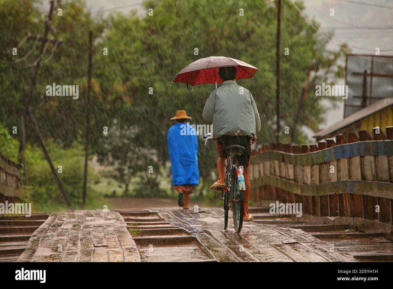 Myanmar, Menschen auf der Fußgängerbrücke in Monsun-Niederschläge Stockfoto