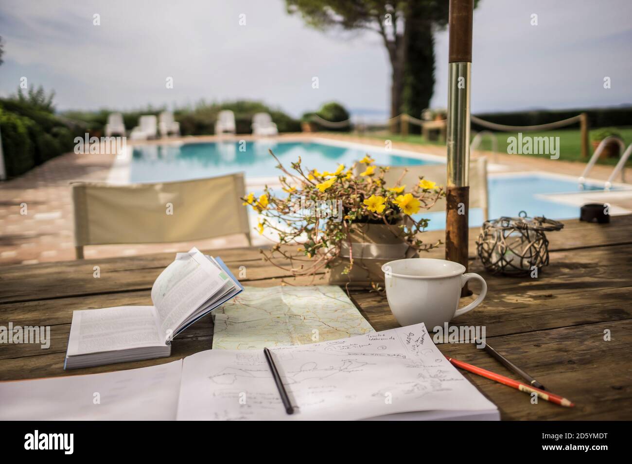 Italien, Toskana, Reiseführer, Karte und Notebook auf Tisch am Pool Stockfoto