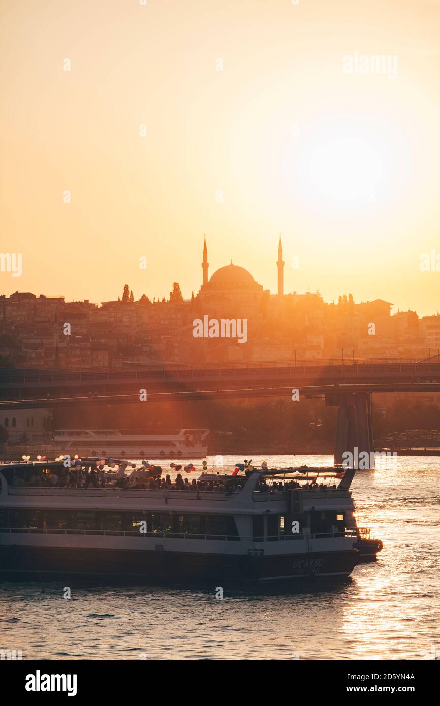 Türkei, Istanbul, Blick auf das Fährschiff auf dem Bosporus mit Moschee-Silhouette bei Sonnenuntergang Stockfoto