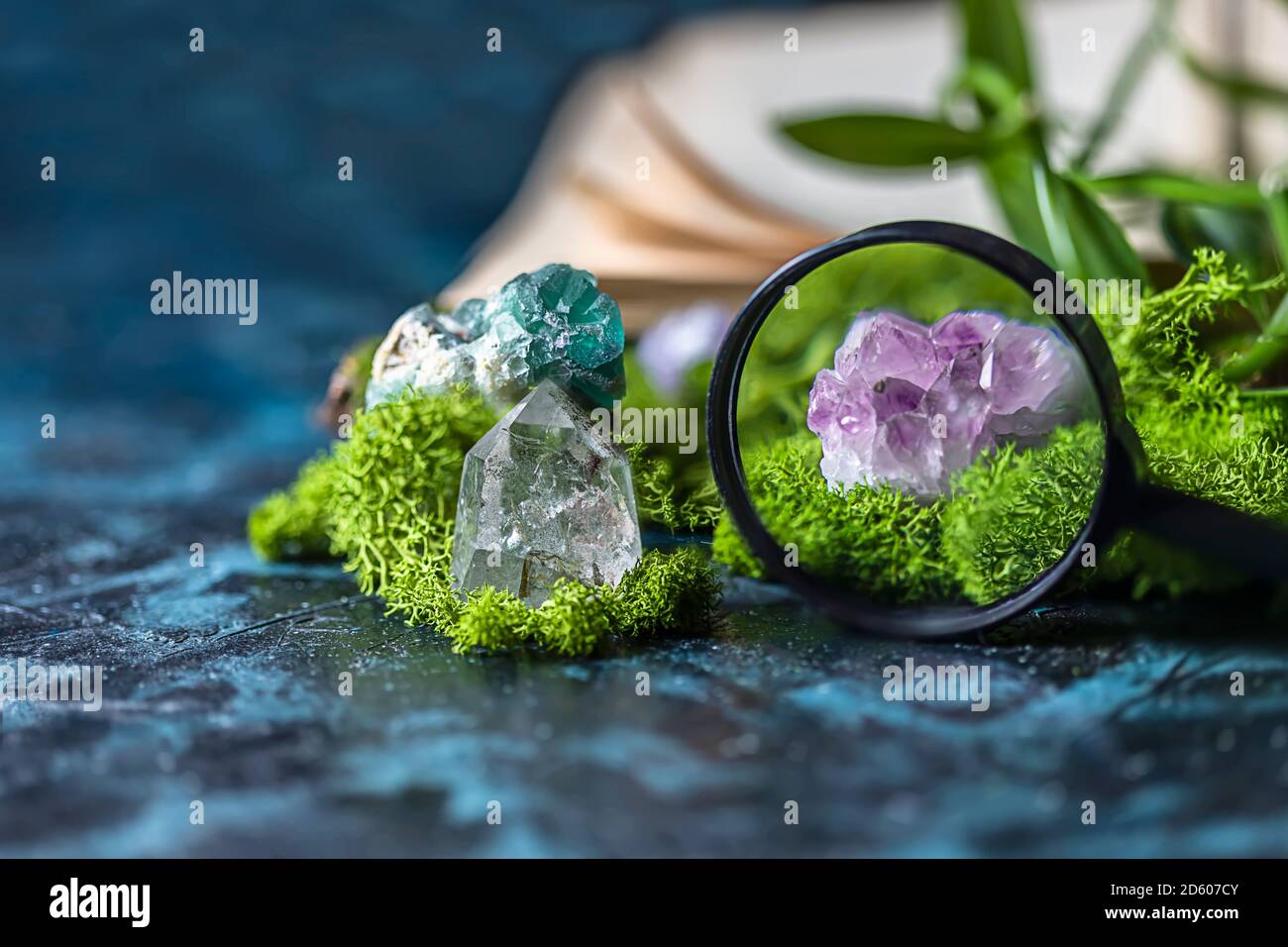 Lupe und kristalline Mineralien für Meditation, Moos, Buch. Magic Rock für die Heilung von Steinen. Mineralien für Entspannung, Hexerei. Stockfoto