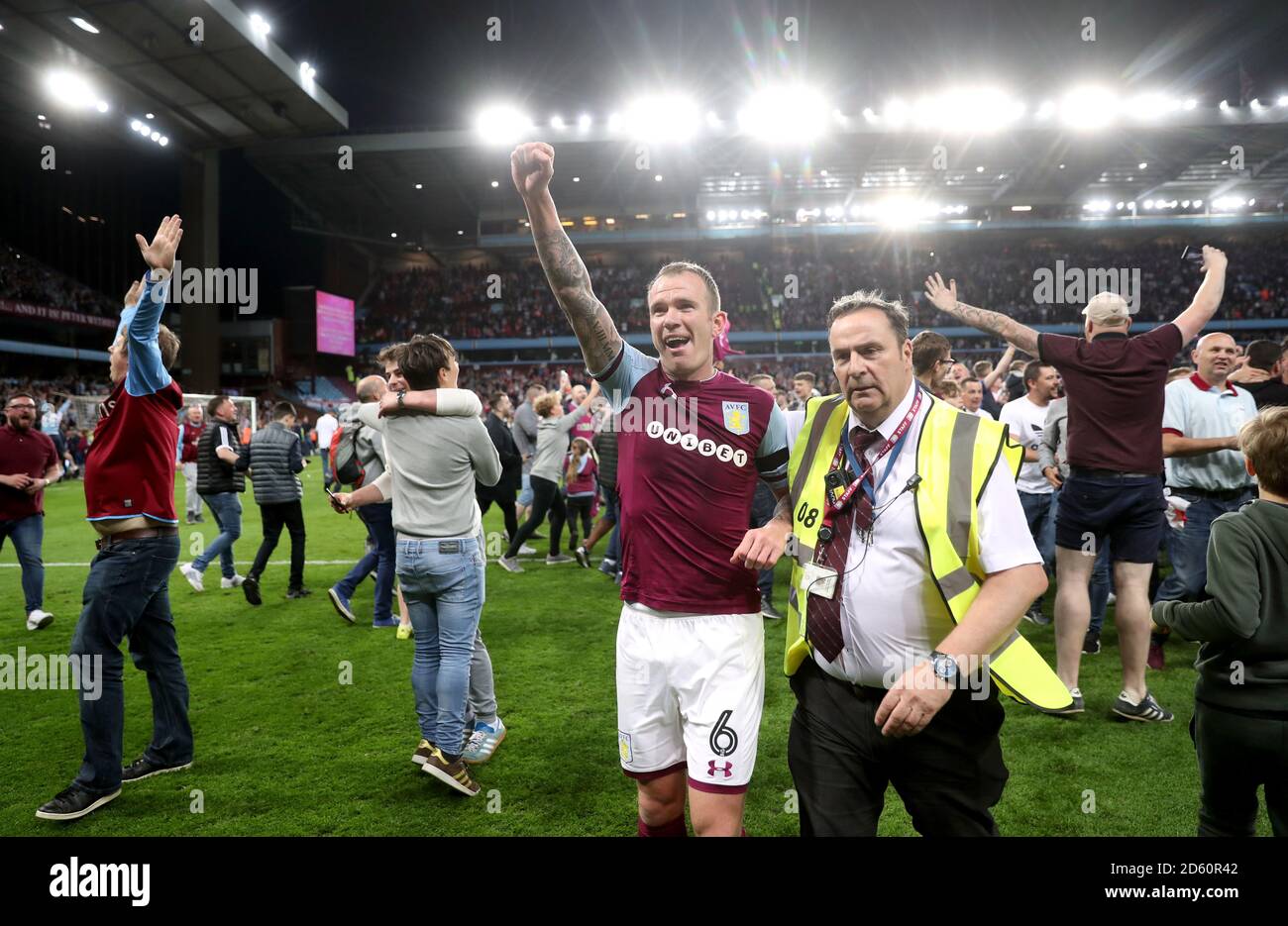 Glenn Whelan von Aston Villa wird von Stewards vom Spielfeld geführt, während Fans das Spielfeld überfluten, um am Ende des Sky Bet Championship Playoff-Spiels in Villa Park, Birmingham, zu feiern Stockfoto