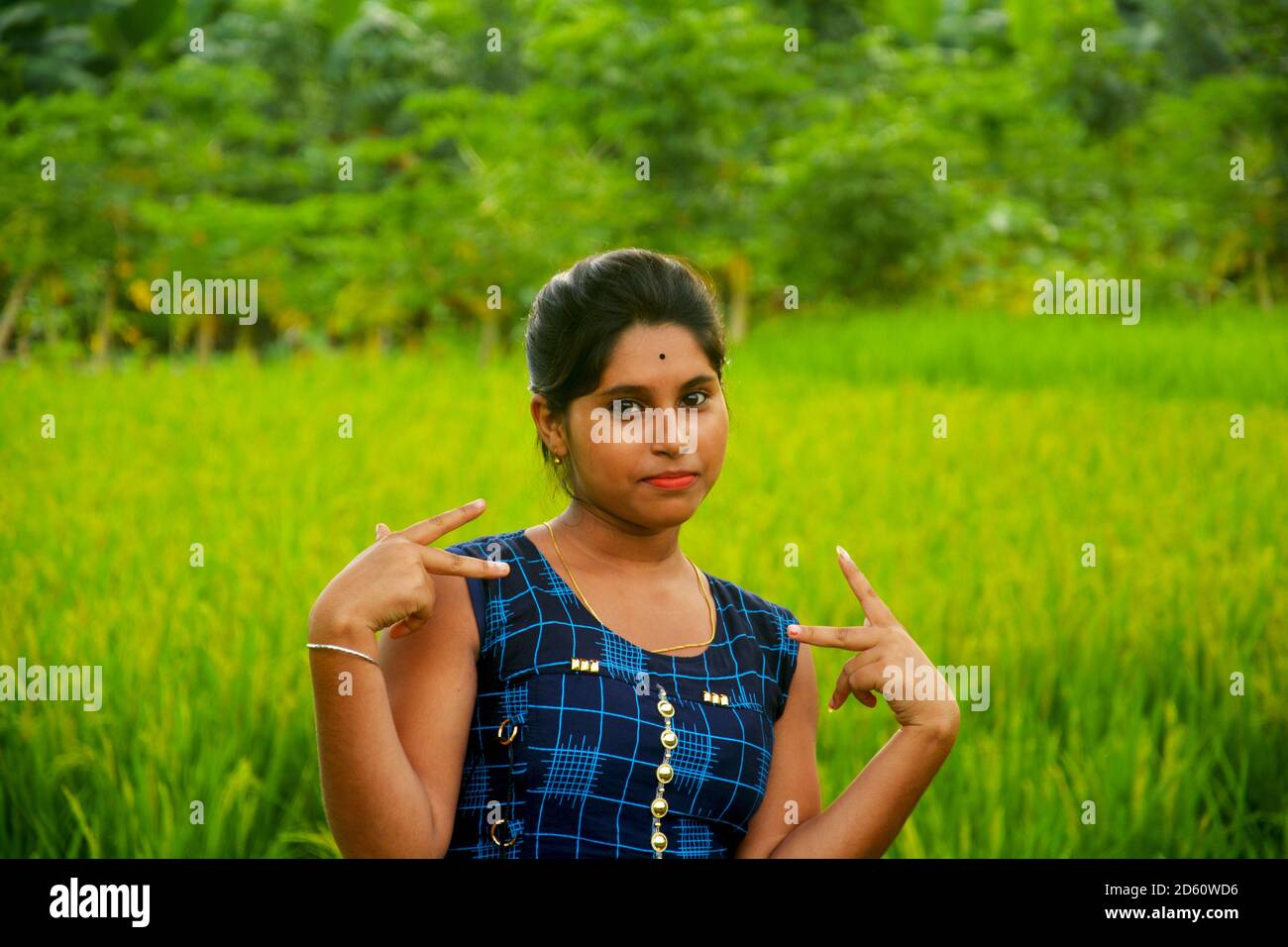 Nahaufnahme eines Teenagers Mädchen tragen traditionelle indische Kleidung in einem landwirtschaftlichen Feld mit grünen Reisreis, selektive Fokussierung Stockfoto