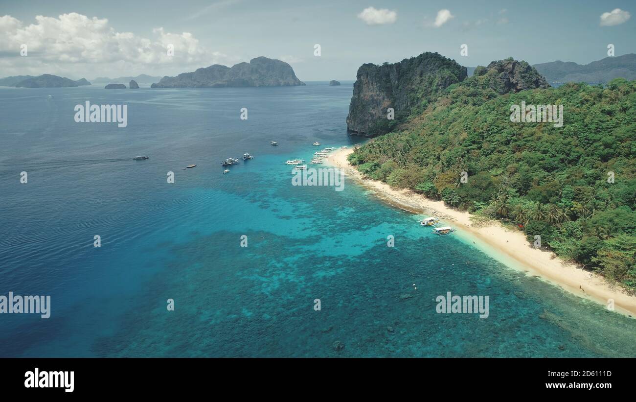 Kreuzfahrt an der tropischen Küste auf Booten, Schiffen. Touristen entspannen und schwimmen in seichtem Wasser in der Nähe der Küste. Grüner tropischer Dschungelwald am Sandstrand. Cinematic Paradise Urlaubstour für Reisende Stockfoto