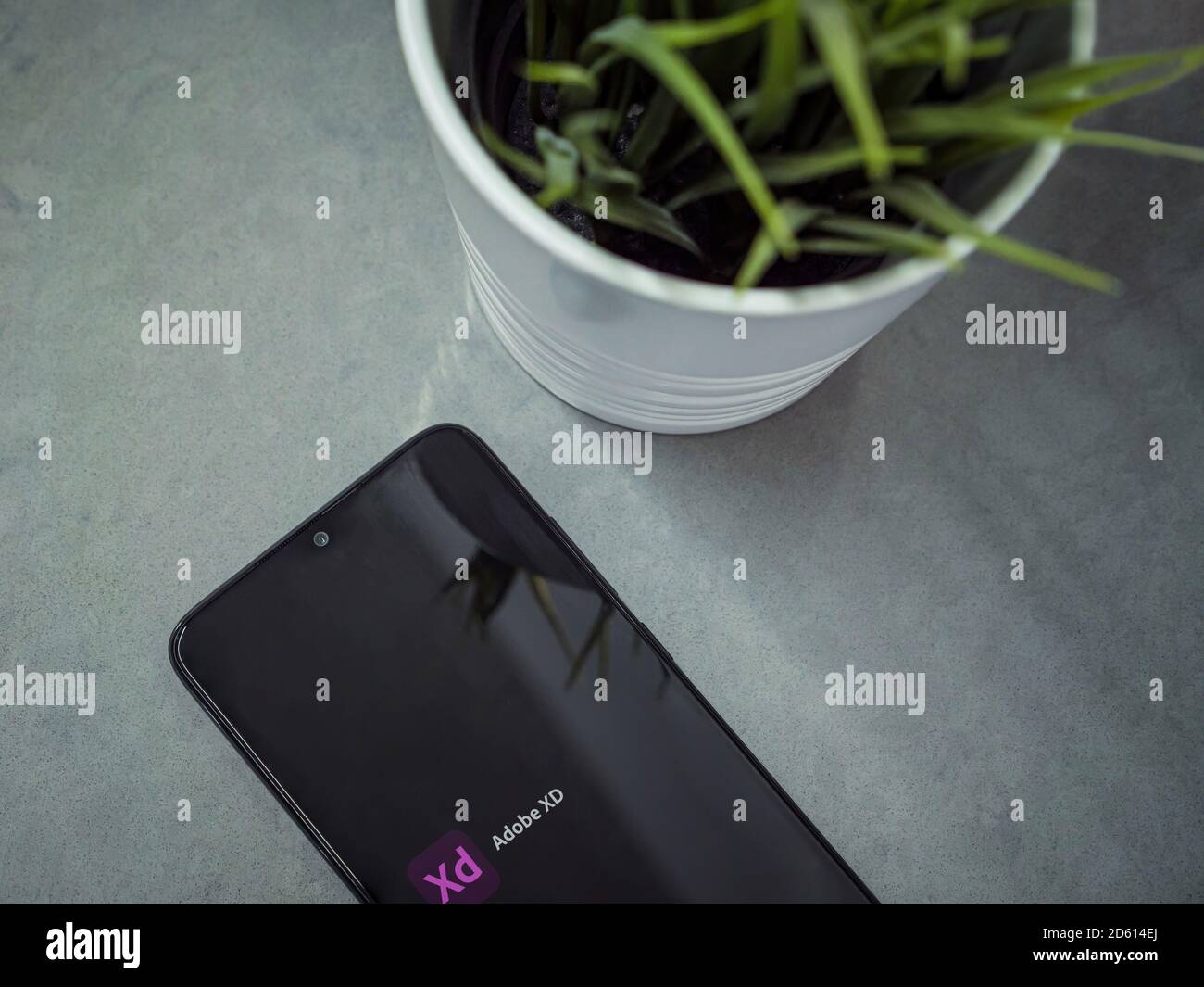 LOD, Israel - 8. Juli 2020: Moderner minimalistischer Büroarbeitsplatz mit schwarzem Smartphone mit Adobe XD App Launch Screen mit Logo auf einer Marmorrückseite Stockfoto