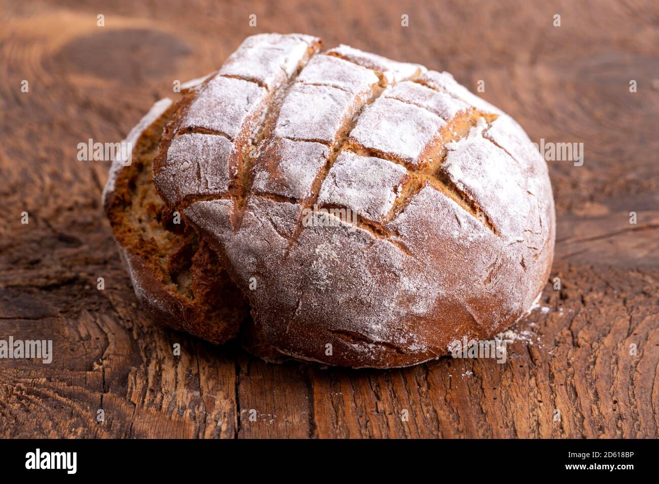 Frisches Roggenbrot auf dunklem Holz Stockfoto