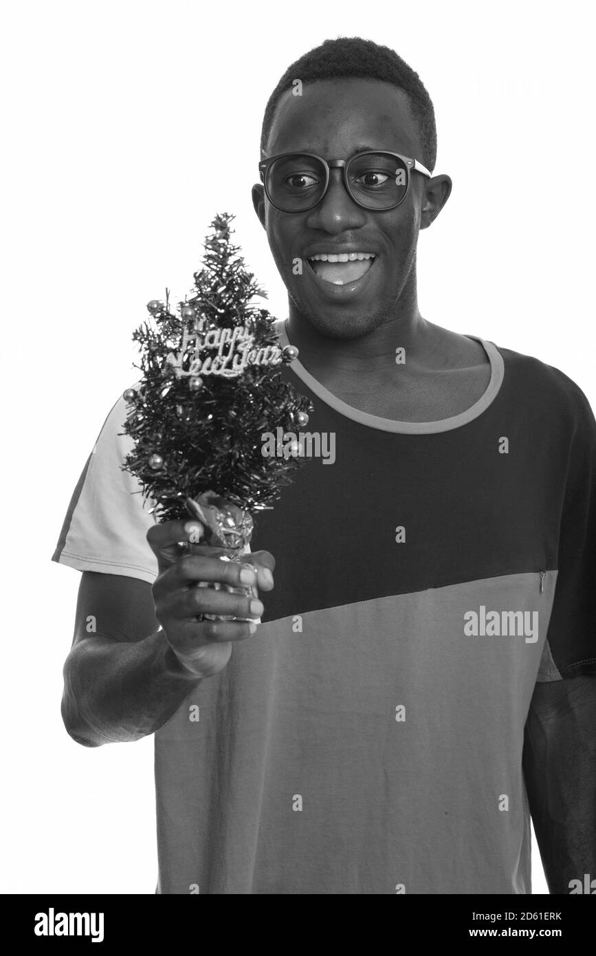 Junge glücklich afrikanischer Mann lächelnd und suchen halten Frohes Neues Jahr Tree begeistert Stockfoto