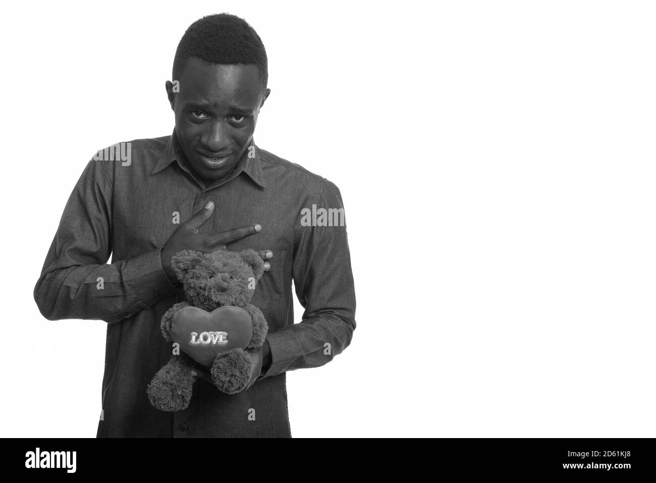 Junge afrikanische Mann traurig halten Teddybär mit Herz und Liebe Zeichen Stockfoto