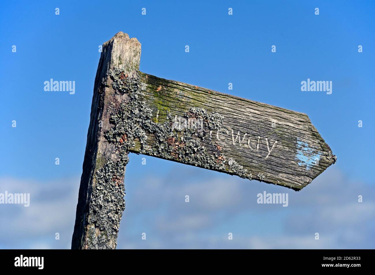 Hölzerne öffentliche Brücke Zeichen stark mit Flechten verkrustet. Roan Edge, New Huttton, Kendal, Cumbria, England, Vereinigtes Königreich, Europa. Stockfoto