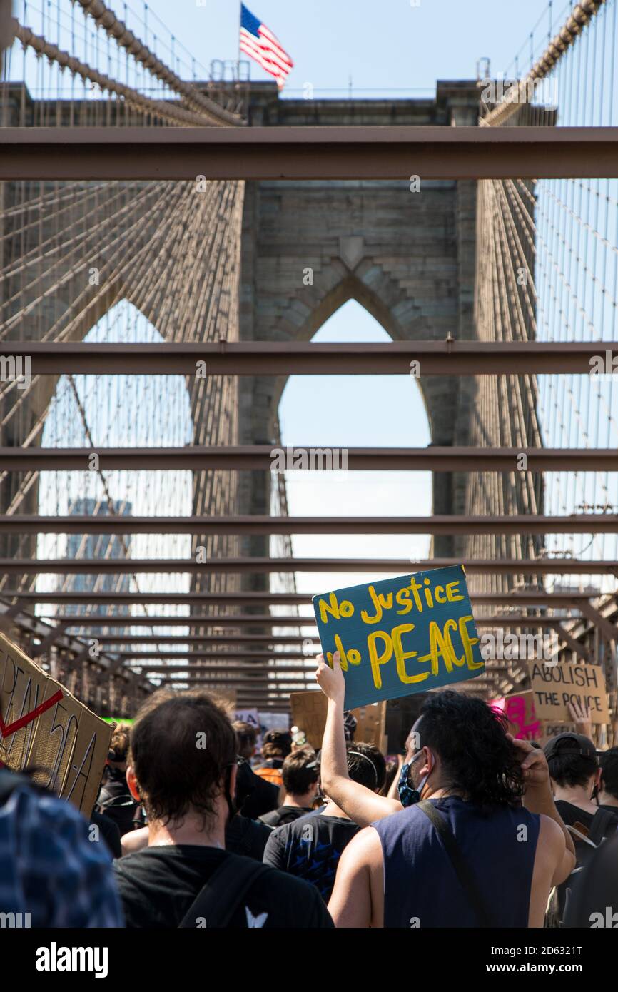 Massen von Protestierenden mit Schildern, 'No Justice No Peace', marschieren über die Brooklyn Bridge während des 6. März, New York City, New York, USA Stockfoto