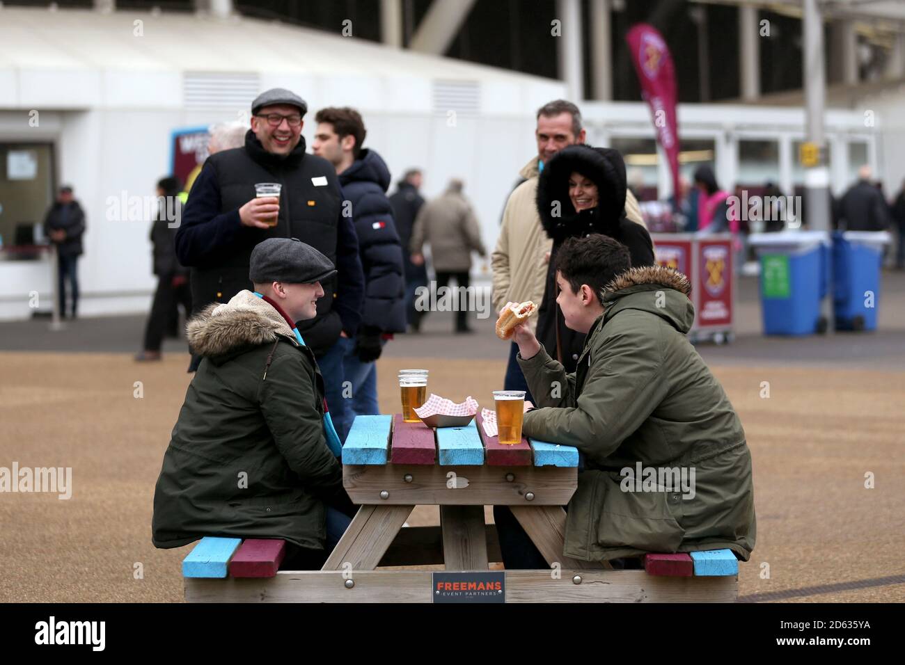 Fans sitzen vor dem Londoner Stadion vor dem Westen Ham United gegen Arsenal Spiel Stockfoto