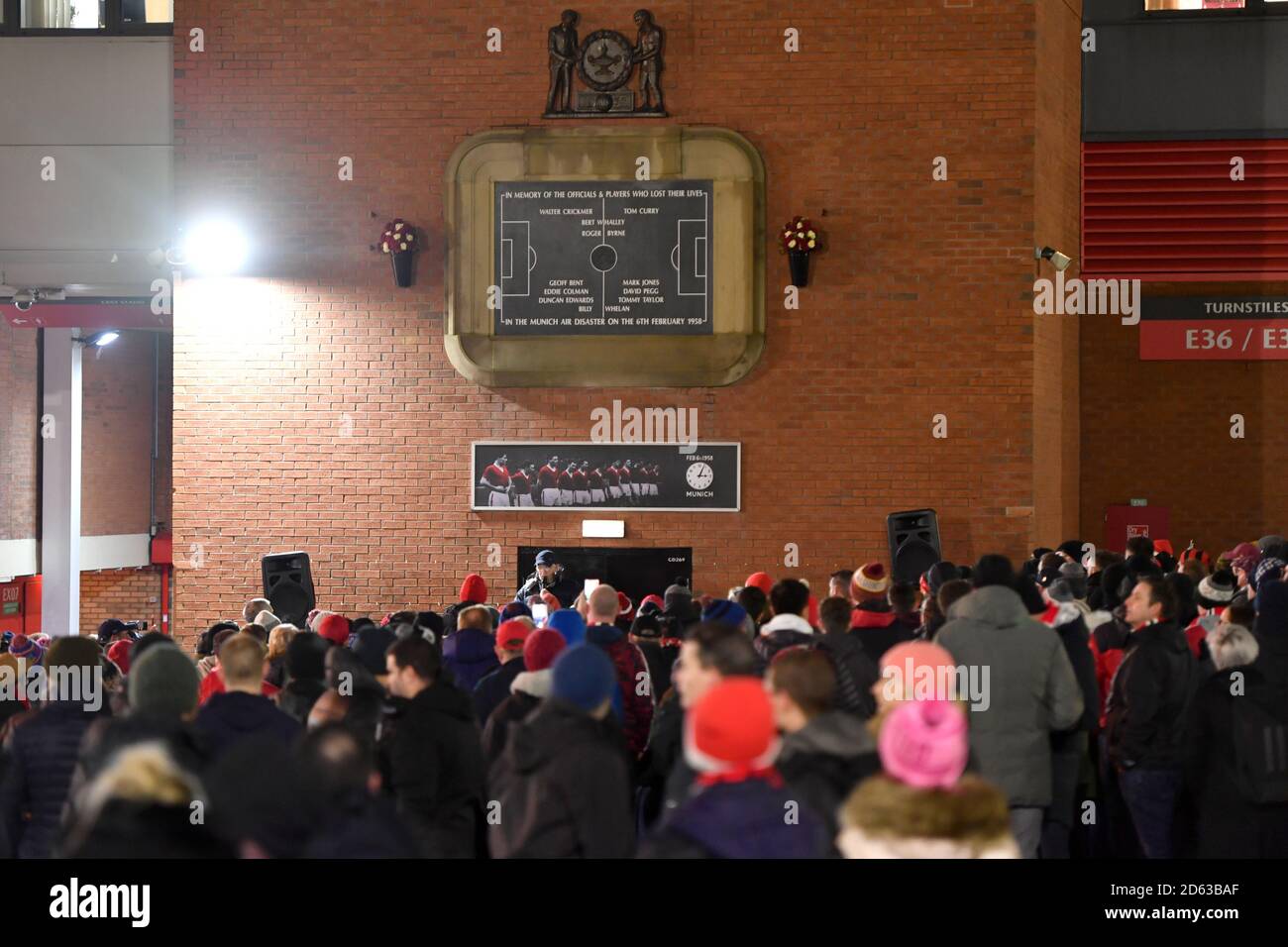 Fußballfans hören eine Gedenkfeier zum Gedenken an die Flugzeugabsturz in München unter der Münchner Uhr vor dem alten Trafford Stockfoto