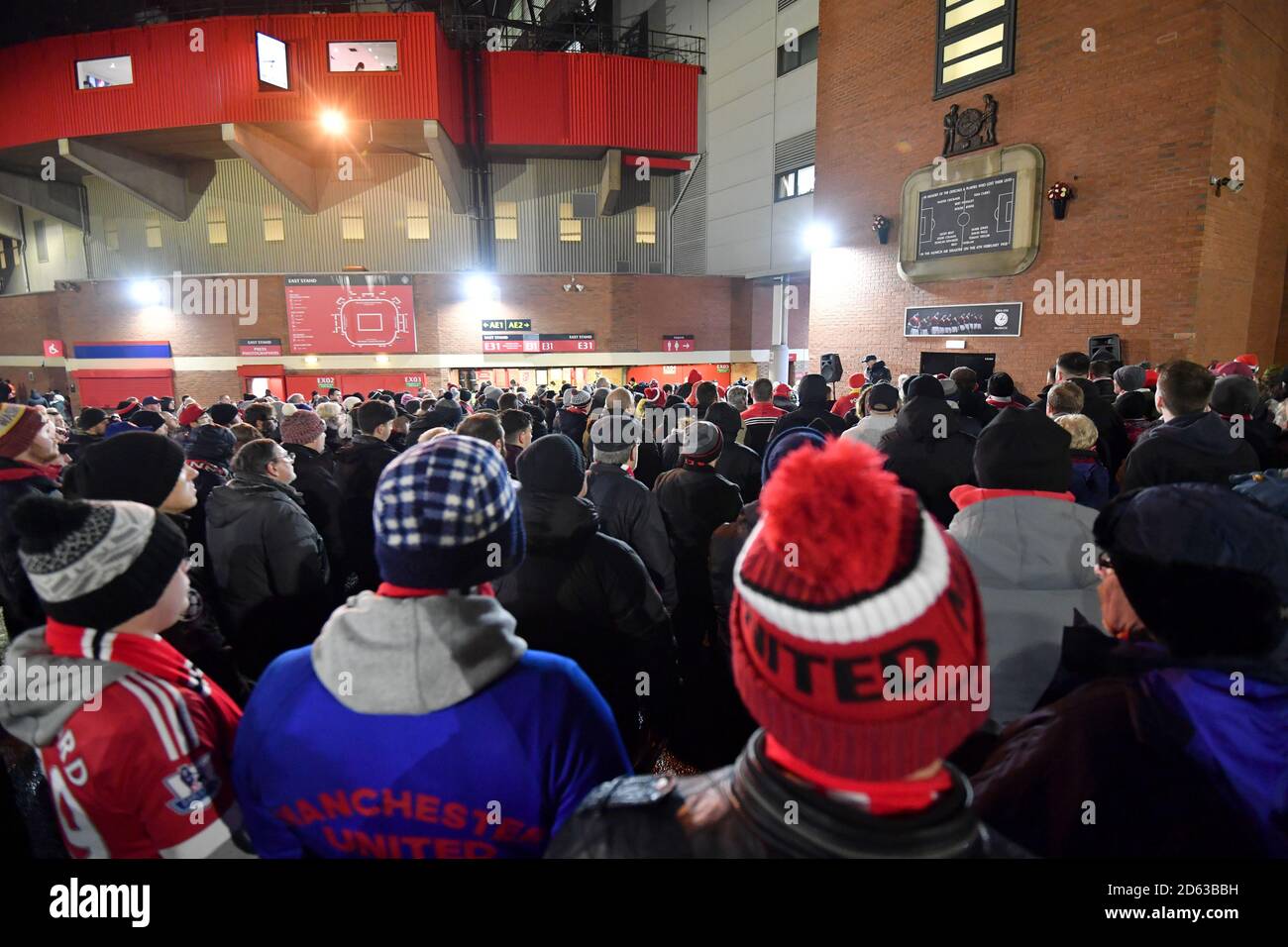 Fußballfans hören eine Gedenkfeier zum Gedenken an die Flugzeugabsturz in München unter der Münchner Uhr vor dem alten Trafford Stockfoto