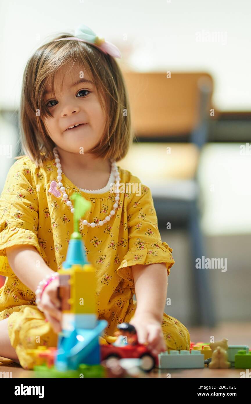 Kleine Mädchen Kind im Kindergarten spielen mit bunten Ziegeln Stockfoto