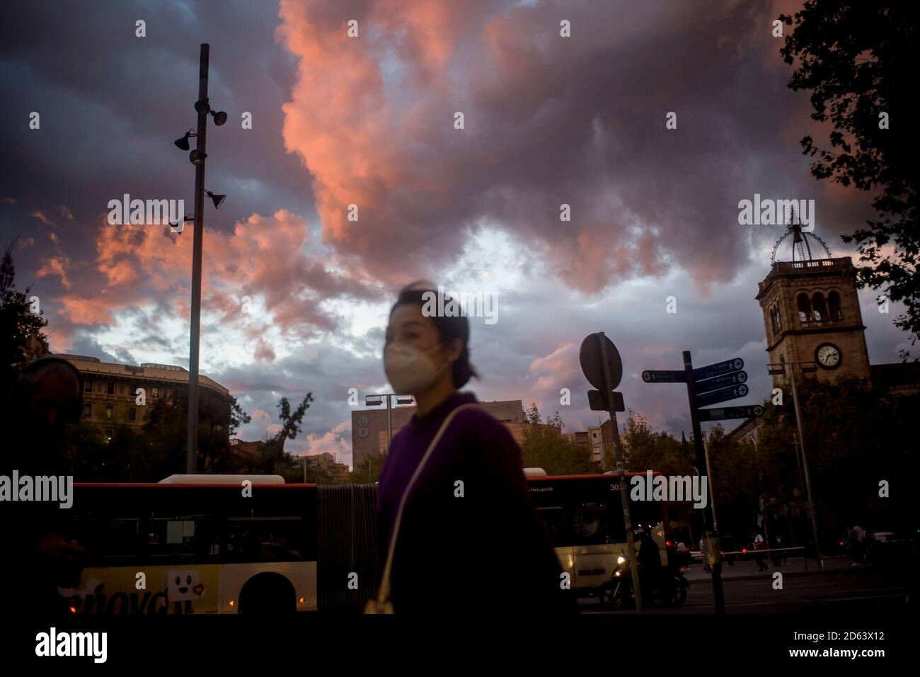 14. Oktober 2020, Barcelona, Katalonien, Spanien: Eine Frau mit einer schützenden Gesichtsmaske, um die Ausbreitung von Coronavirus zu verhindern, geht unter dem herbstlichen bewölkten Himmel von Barcelona. Aufgrund steigender Fälle schließt die katalanische Regionalregierung zwei Wochen lang Restaurants und Bars, um die Ausbreitung des Coronavirus zu verlangsamen. Quelle: Jordi Boixareu/Alamy Live News Stockfoto