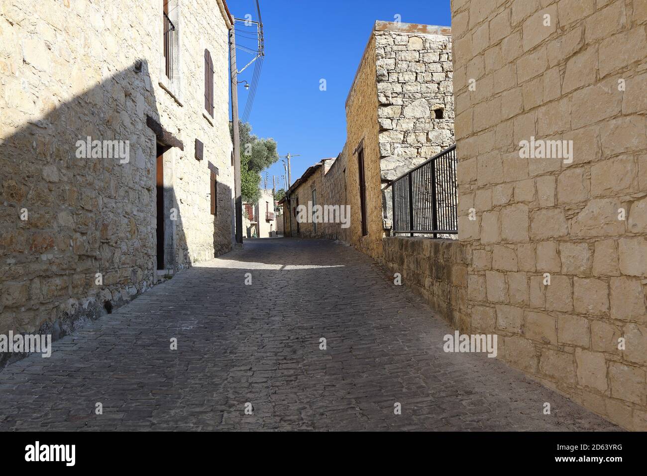 Leer, getrocknet, ohne Menschen schmale Straße in Zypern Dorf, traditionelle Schläuche, Gebäude aus Steinen gebaut, blauer Himmel Stockfoto
