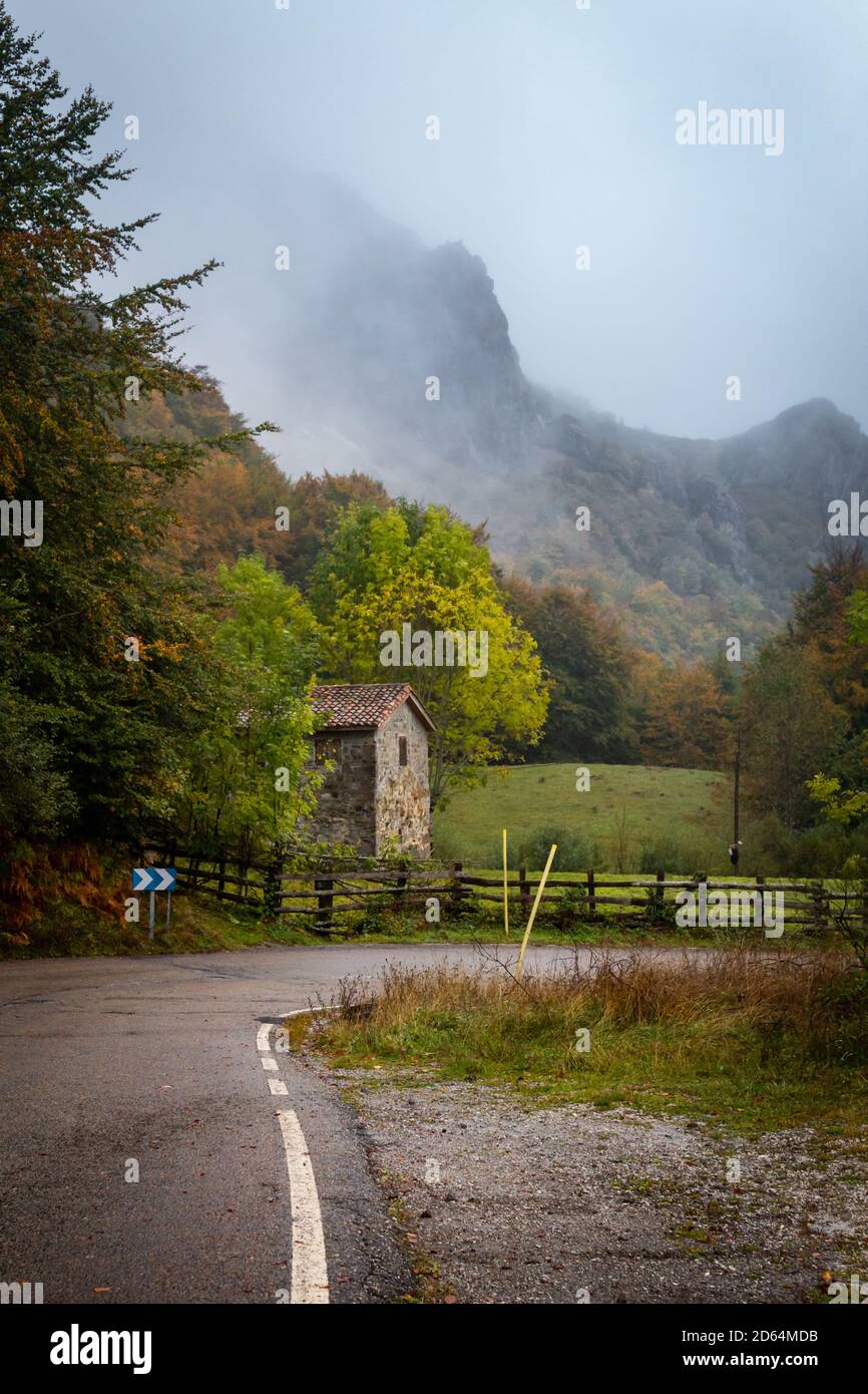 Nebel kommt den Berg hinunter und droht das Haus und die Straße zu bedecken. Stockfoto