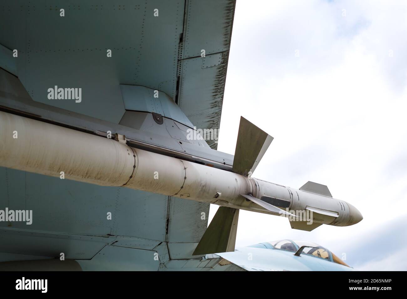 Die Luft-Luft-Rakete wird unter dem Flügel des Flugzeugs aufgehängt. Fragment der Ebene Stockfoto