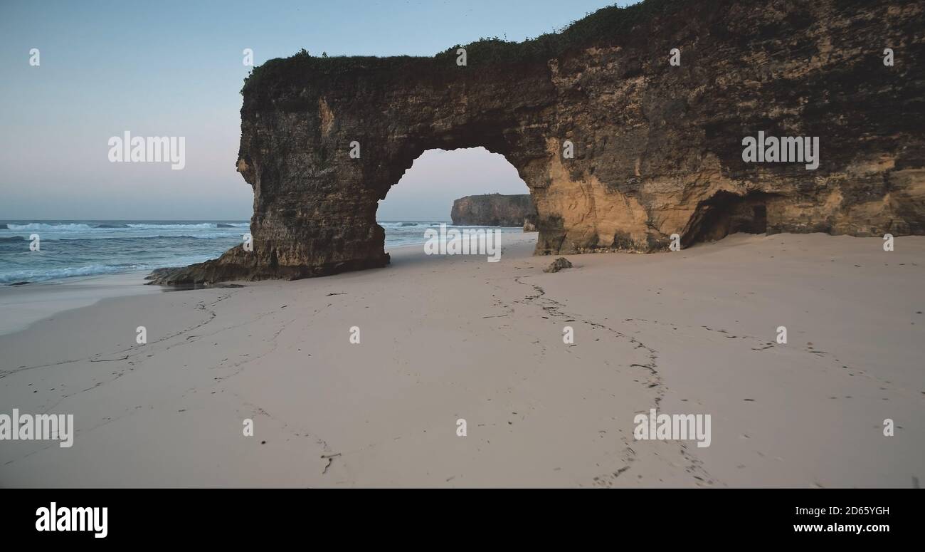 Einzigartige geologische Formation von Batu Bolong - riesiges Loch in Felswand am Sandstrand, Meeresbucht Luftaufnahme. Felsenküste von Bawana Beach, Sumba Island, Indonesien, Asien. Touristische Wahrzeichen Drohne erschossen Stockfoto