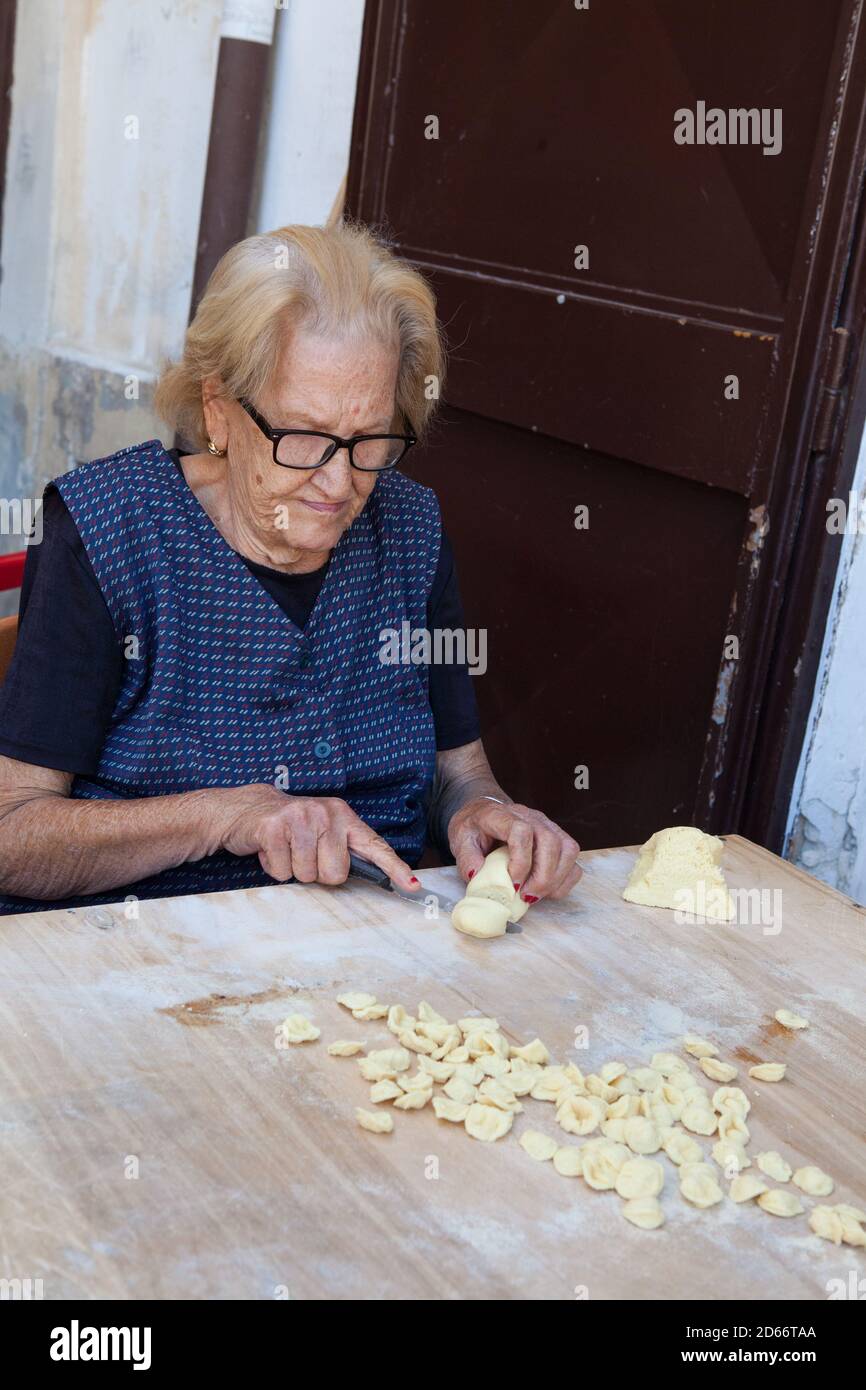 Frau, die Pasta (Orecchiette) aus Teig in der Altstadt von Bari, Italien Stockfoto