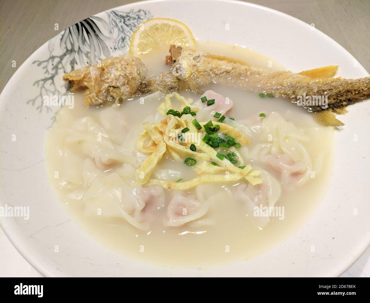 Gebratener Fisch und Knödel in der weißen Suppe Schüssel zum Essen Stockfoto