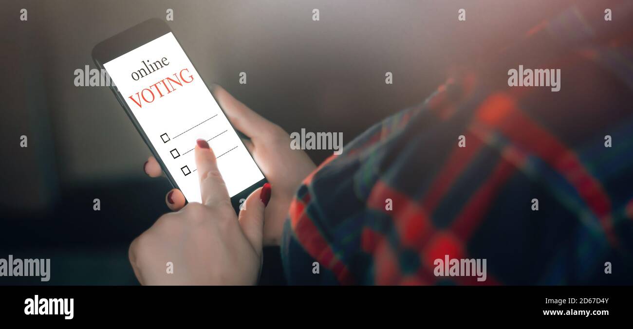 Frau stimmt online mit dem Telefon. Abstimmung und Wahlen Konzept. Stockfoto