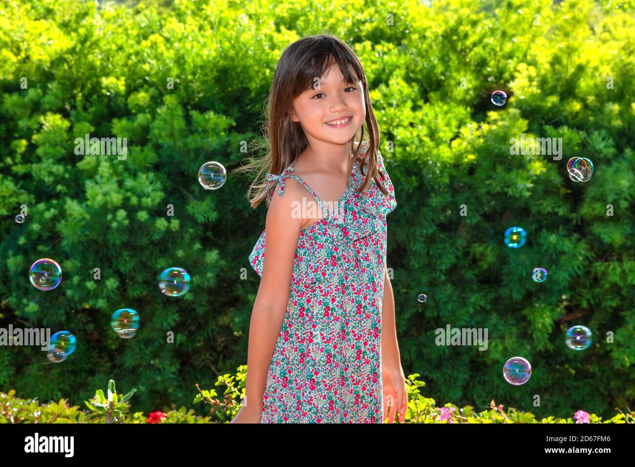Acht Jahre altes Mädchen, umgeben von Seifenblasen Stockfoto