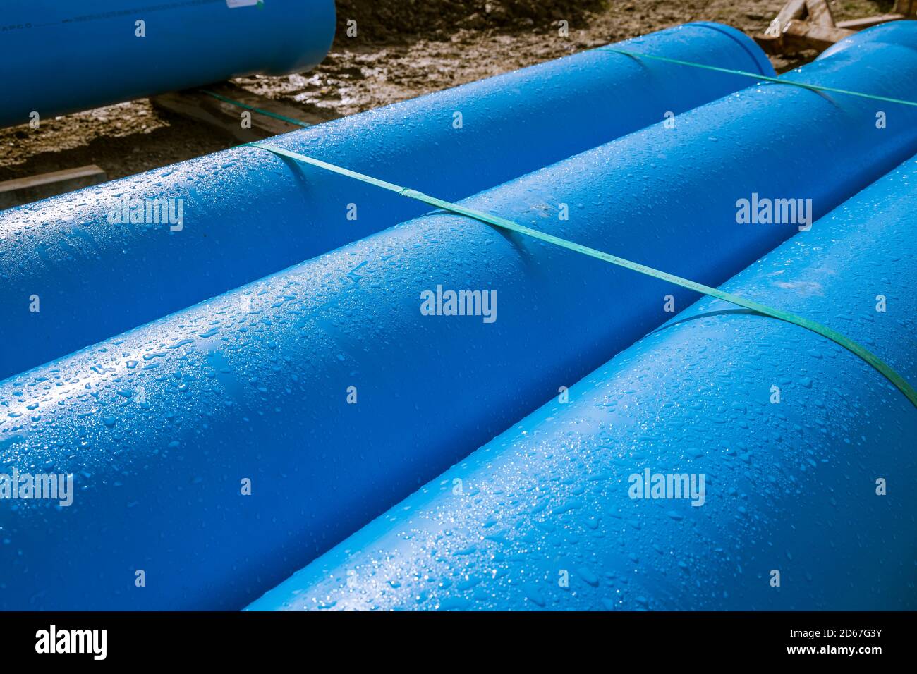 3 blaue Rohre mit Tauwasser-Tröpfchen. Stockfoto