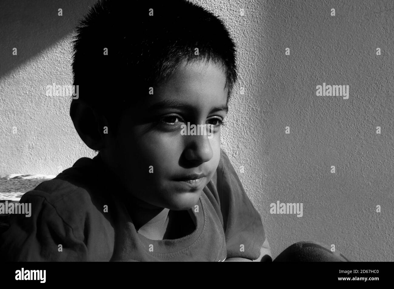 Eine Nahaufnahme eines indischen Jungen, der Schlüssellicht im morgendlichen Schwarz-Weiß-Foto sieht, Kalaburagi, Karnataka/Indien-Oktober 09 2020 Stockfoto