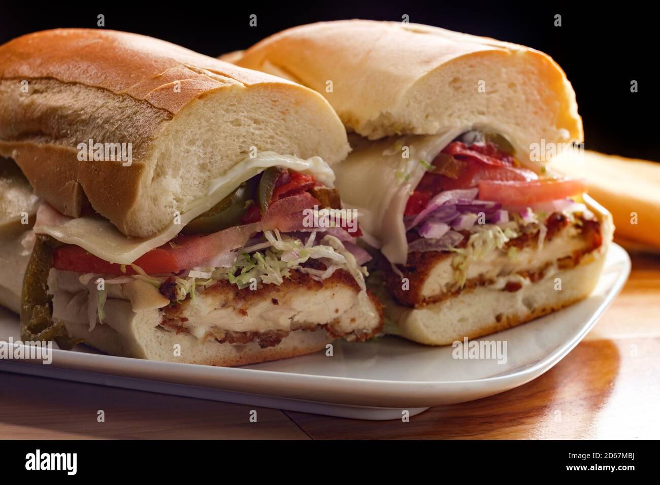 Italiener Chicken Fried Steak Sandwich hogie mit geschredderten Salat Tomate Hot Paprika und rote Zwiebel Stockfoto