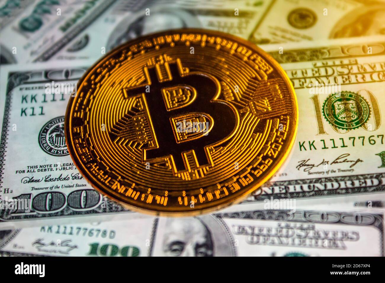 Bitcoin Münze vor dem Hintergrund von uns Dollar. Eine Menge amerikanischer Gelddollar und Goldbitcoin. Hintergrund von Geld und Kryptowährung.Geld zurück Stockfoto