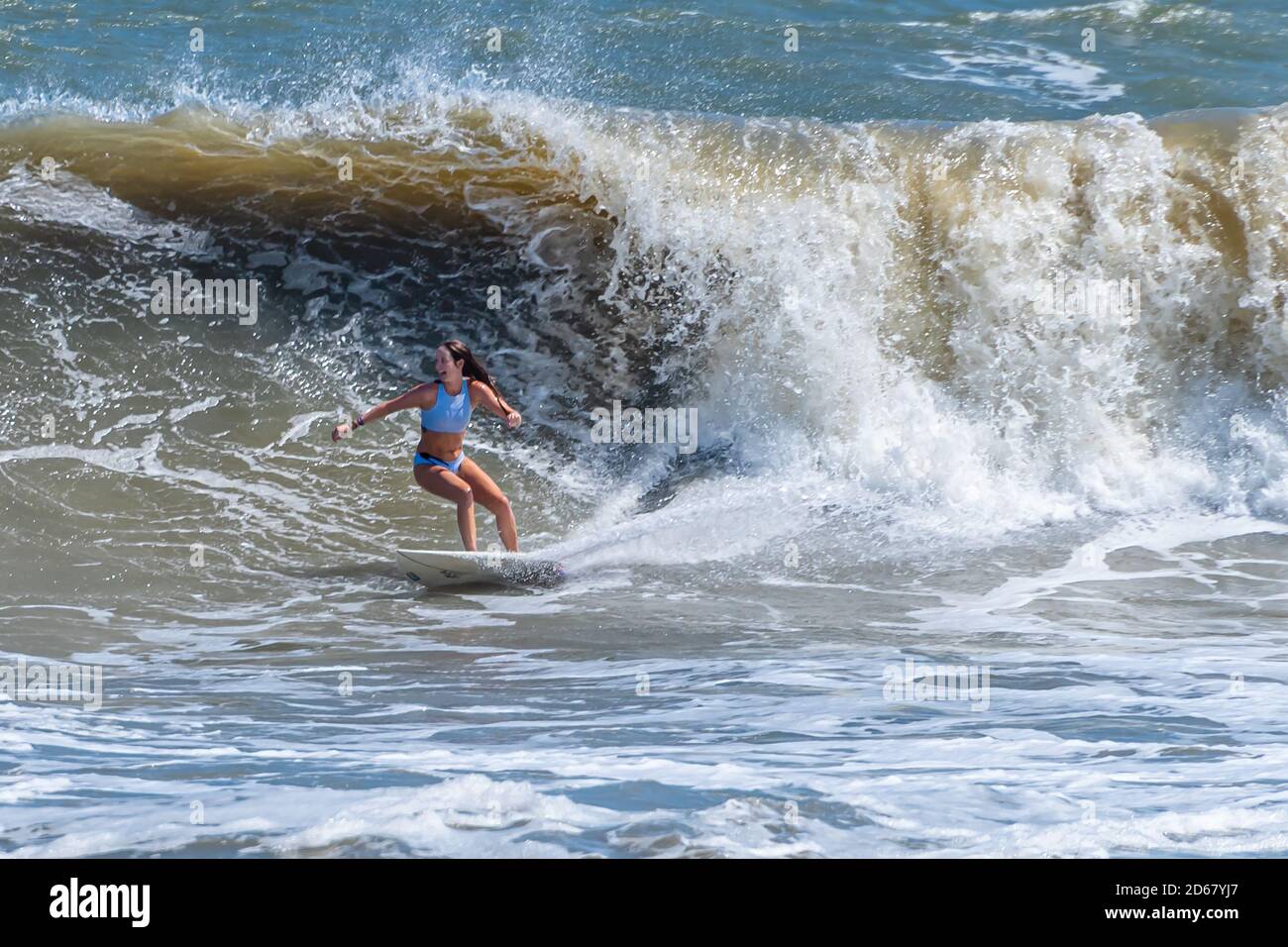 Weibliche Surferin genießt einen großen Wellentag bei The Poles in Jacksonville, Florida. (USA) Stockfoto