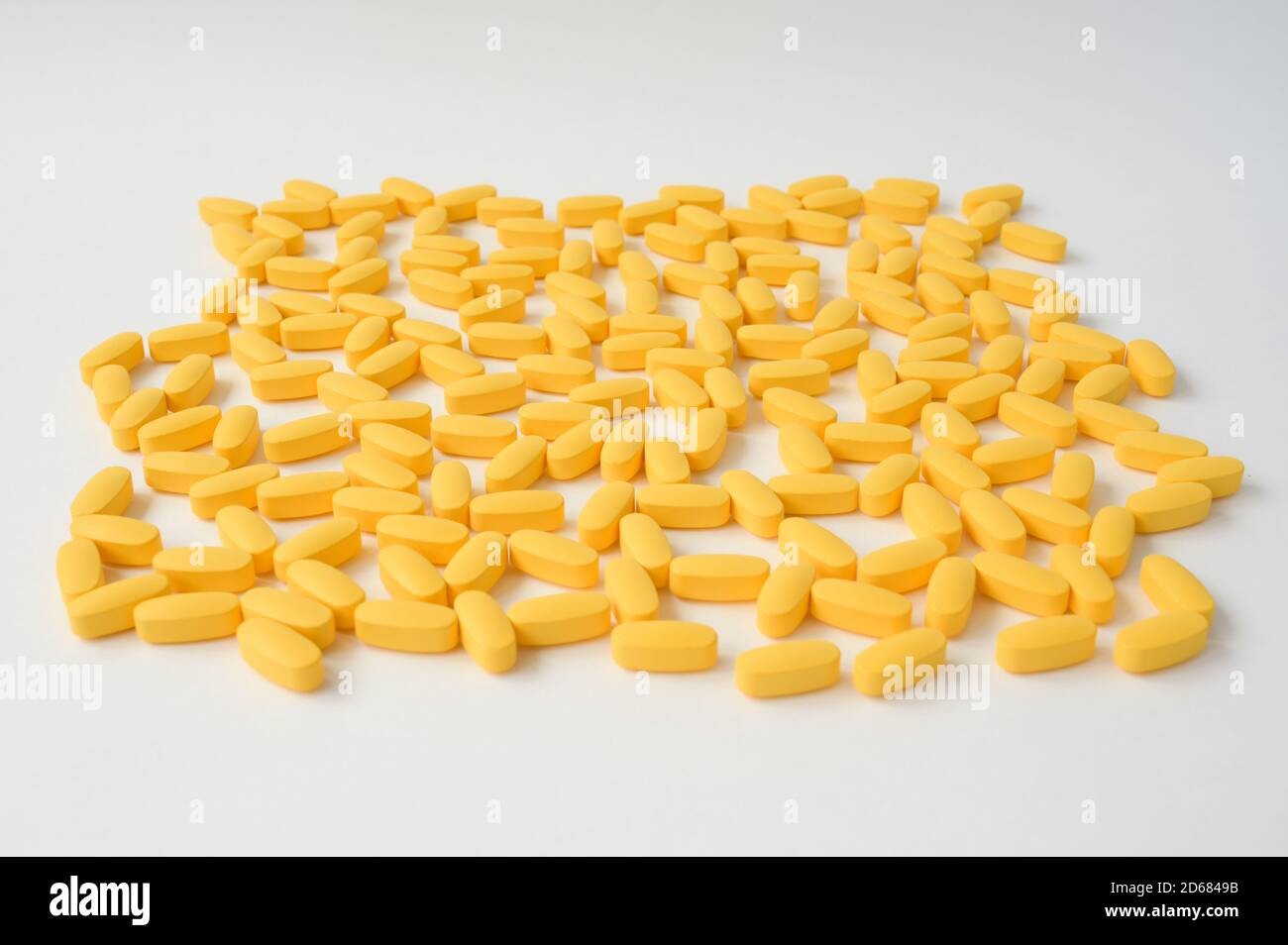 Pharmazie Industrie Konzept der Handvoll gelber Tabletten liegen auf Weiße Oberfläche Stockfoto